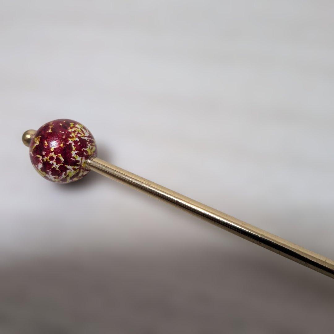 Single-pronged hairpin featuring a red ball